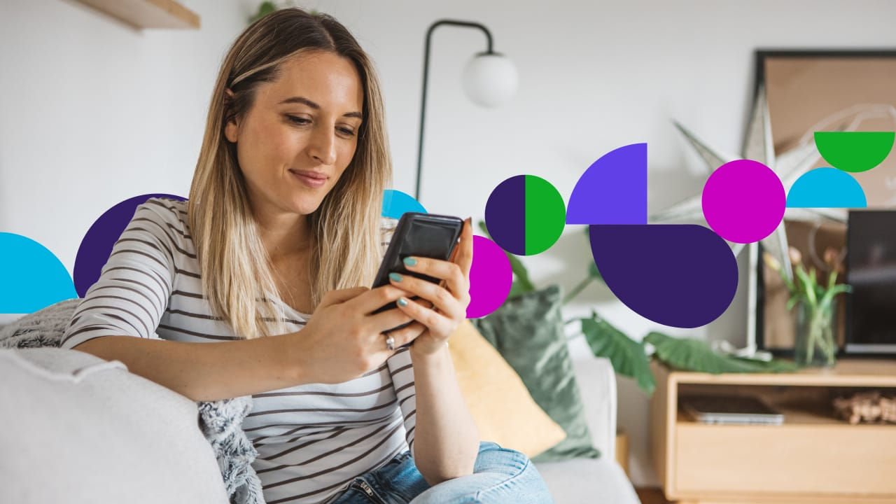 Young woman sitting on couch looking at phone with different color pavers in background